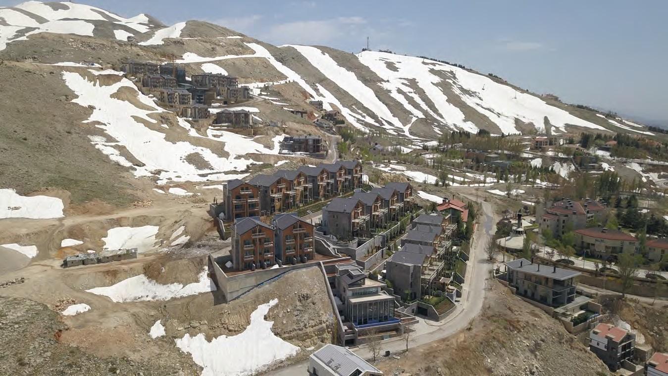Le site de montagne de Tilal Faqra, soixante chalets vus depuis les hauteurs enneigées.